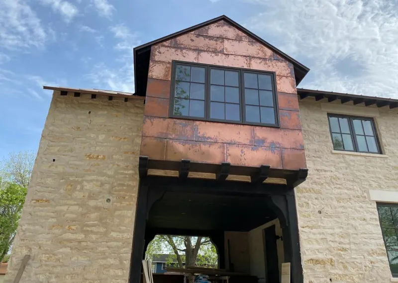 Copper metal panel facade on a stone building for Roof Repair in West Warwick